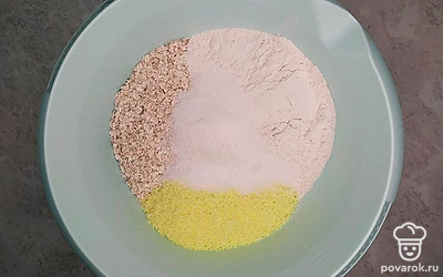 Апельсин хорошо помойте, обсушите полотенцем и натрите на мелкой терке, старайтесь снимать именно цедру – цветную часть, в ней содержатся все ароматные масла, а белая – горчит. Соедините в большой миске муку, овсяные хлопья, кокосовую стружку, соль, сахар, ванильный сахар, добавьте цедру апельсина, и все хорошо перемешайте.