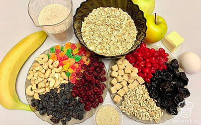 Все сухофрукты залейте на 15-20 минут холодной водой, затем промойте. Яблоки промойте, очистите от косточек и кожуры. Банан очистите и нарежьте. Орехи и подсолнечные семечки промойте. Масло заранее достаньте из холодильника, чтобы оно было мягким. Яйцо разделите на желток и белок. Противень застелите пергаментом.