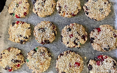 Сформируйте из получившейся массы круглые плоские печенья. Если не получается вручную, используйте для формовки пластиковую крышку для банки. Выложите печенья на пергаментную бумагу, присыпьте каждое семенами кунжута. Выпекайте в разогретой до 180 °C духовке около 25 минут.