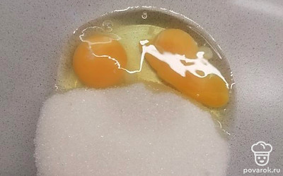 Вбейте 2 яйца в миску и высыпьте весь сахар (и обычный, и ванильный). 