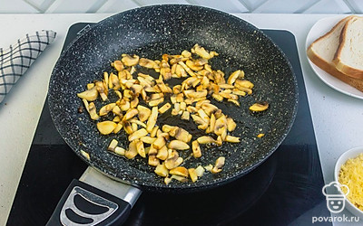 Грибы нарежьте мелким кубиком. Чеснок измельчите. Разогрейте сковороду со сливочным маслом и каплей растительного, чтобы не горело. Обжарьте грибы с чесноком 5 минут, помешивая.