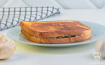 Соберите сэндвич. Сметанный соус смешайте с обжаренными грибами. Тосты подсушите на сухой сковороде или в тостере. Смажьте один тост получившейся заправкой и накройте вторым. Разрежьте пополам и подавайте.