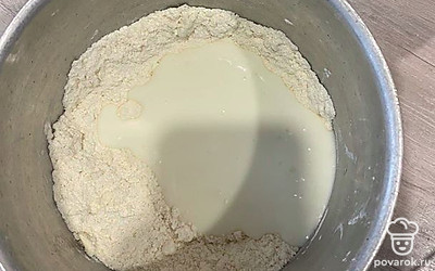 В полученную массу добавьте сметану и замесите тесто.