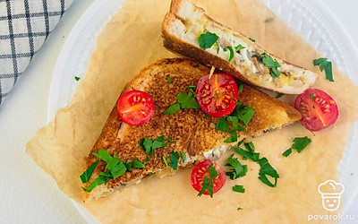 Готовый сэндвич украсьте свежей зеленью и томатами черри.