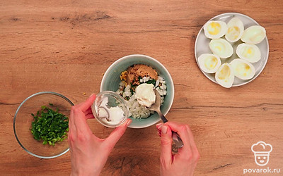 Добавьте мелко рубленный укроп, лук, майонез и тщательно перемешайте начинку. Заполните яичные белки начинкой.
