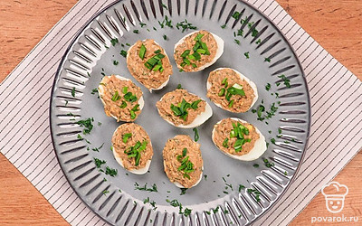 Яйца, фаршированные печенью трески, выложите на сервировочное блюдо, края тарелки посыпьте измельченным укропом.