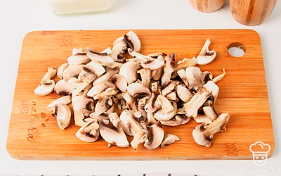 Очищенный лук нарежьте полукольцами, чеснок мелкими кубиками, а шампиньоны тонкими слайсами.