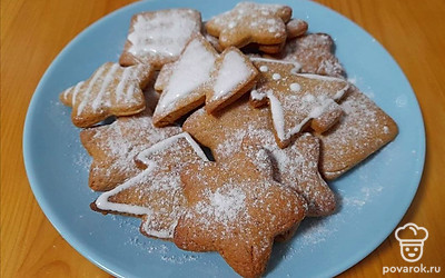 Украсьте печенье сахарной глазурью и дайте ей застыть. Можете использовать для украшения печенья различные кондитерские конфетти «рождественских» цветов: красные, зеленые, золотистые. Присыпьте немного сахарной пудрой.