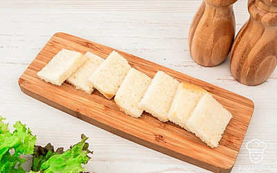 Нарежьте багет ломтиками толщиной 5 мм. У каждого ломтика срежьте корочки.