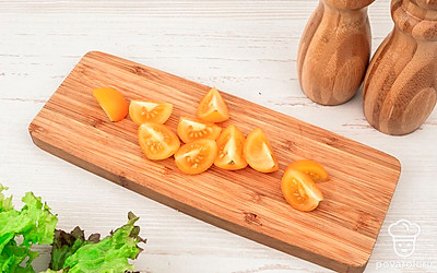 Помидоры черри разрежьте на четыре части.