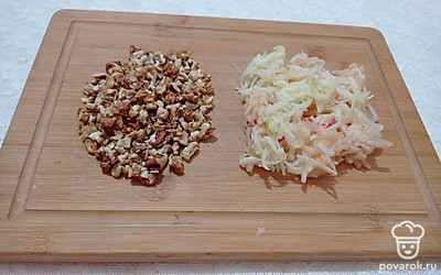 Орехи очистите от скорлупы и мелко нарубите. Яблоко помойте, очистите от кожуры и натрите на крупной терке. Полейте тертое яблоко медом.