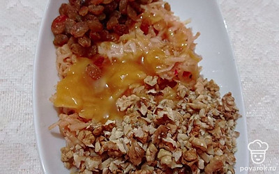 Очищенные и измельченные орехи отправьте в миску к яблокам. Добавьте сюда же изюм. По желанию посыпьте сахаром и перемешайте.