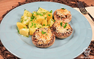 Готовые шампиньоны, фаршированные сметаной, подавайте с гарниром из картофеля.