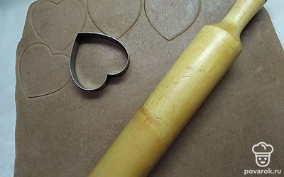 Посыпьте стол оставшейся мукой и раскатайте тесто в тонкий пласт. Для вырезания печенья используйте специальные формы или подручные инструменты, например стакан.