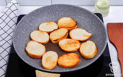 Нарежьте белый хлеб ломтиками среднего размера. Обжарьте хлеб с двух сторон на небольшом количестве растительного масла до хрустящей корочки.