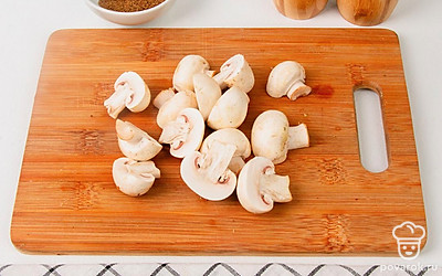 Разрежьте каждый шампиньон пополам. Если ножки кажутся вам слишком длинными, укоротите их.