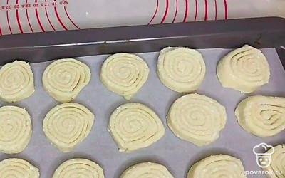 Возьмите форму для запекания, на дно положите пергаментную бумагу и выложите сверху заготовки для печенья.