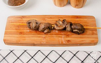 Шпажки с нанизанными шампиньонами установите на края формы для запекания, чтобы грибы не касались ее стенок и дна. Запекайте “шашлык” в духовке при температуре около 180 градусов в течение 20-25 минут. Готовые грибы можно съесть сразу горячими, но и холодными они не теряют своих вкусовых качеств.