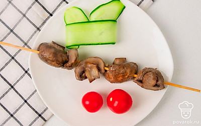 Подавайте запеченные шампиньоны, не снимая со шпажки, как шашлык. Выложите их на тарелку и украсьте свежими помидорками черри и тонким ломтиком огурца - его можно свернуть в причудливую завитушку.