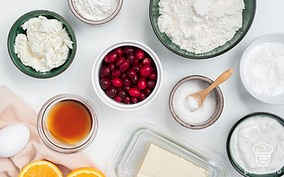 Клюкву промойте и обсушите бумажным полотенцем. Хорошо охладите сливочное масло. Вымойте яйцо. Апельсин промойте, снимите с него теркой цедру. Застелите форму для выпечки пергаментной бумагой.