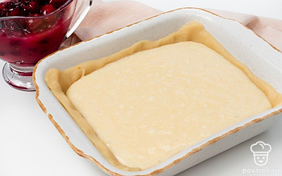 Приготовьте начинку. Сливочный сыр соедините с оставшимся сахаром, сметаной, ванильной эссенцией и яйцом. Смешайте до однородной массы. На остывшем корже распределите сливочный крем, а затем — клюквенный джем. Сверху раскрошите маленький кусочек теста из холодильника и поставьте в духовку еще на 25 минут.