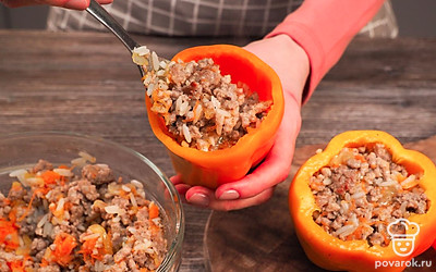 Начините перец и потушите. Начинку выложите в перцы, плотно утрамбуйте. В кастрюле установите перец вертикально, залейте сметанным соусом, долейте воду, чтобы перец был покрыт до верхушки. Поставьте на плиту, дайте закипеть и тушите перец 40 минут. Выключите огонь и дайте блюду настояться 20 минут.