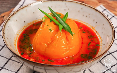 Горячий перец в подливе выложите на порционные тарелки и посыпьте мелко нарезанным зеленым луком.