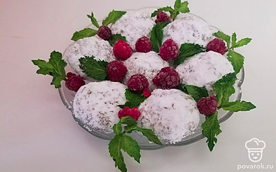 Выложите печенье на тарелку и посыпьте их пудрой, а сверху положите ягоды и листья мяты.