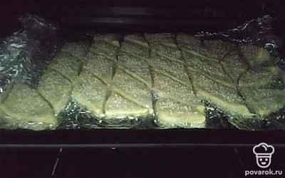Смажьте полученные ромбики молоком с помощью кулинарной кисточки и присыпьте оставшимся кунжутом. Выпекайте крекеры минут 15 при 190 градусах в заранее разогретой духовке. Остудите и подавайте к столу.