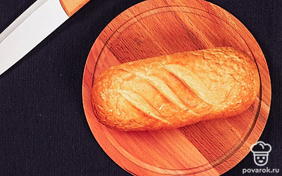 Нарежьте батон на ломти. Их, в свою очередь, на маленькие кубики одинакового размера.