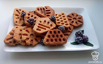 Положите печенье на плоскую тарелку и украсьте ягодами.