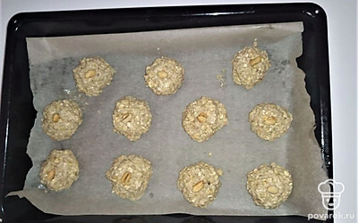 Сформируйте шарики и выложите на противень, застеленный пергаментом, а в середину поставьте арахис. Шарики придавите ложкой. Поставьте печенье в духовку на 30 минут при температуре 190 градусов.