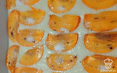 Переложите тесто в форму для выпечки. Сверху выложите нарезанную дольками хурму. Посыпьте сахаром и отправьте в разогретую духовку на 30 минут. 