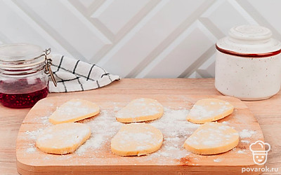 Нарежьте колбаску на кружочки. Присыпьте мукой и немного раскатайте.