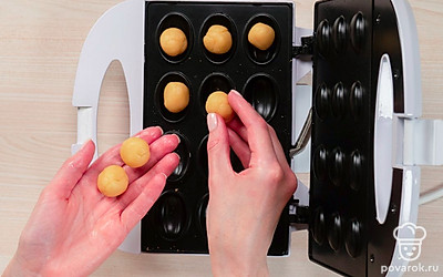 Приступите к приготовлению скорлупок для орешков. Смажьте орешницу растительным маслом. От теста отщипните небольшие кусочки размером примерно с половинку грецкого ореха, скатайте их в шарик и выложите в форму. Размер шариков должен быть чуть меньше, чем ячейка орешницы, чтобы тесто не вытекло из ячейки. Сверху накройте второй половиной формы и жарьте на плите примерно по 1 минуте с каждой стороны на медленном огне. В электрической орешнице жарьте изделия 3-4 минуты. Готовые половинки остудите.