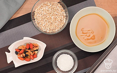 Расположите удобно все ингредиенты. Застелите противень пергаментой бумагой. Если овсяные хлопья крупные, измельчите их в блендере, пока они не превратятся в мелкую крошку. Если изначально они небольшого размера, измельчать их не надо. Совет: При желании можно перемолоть овсяные хлопья до муки. Так консистенция печенья будет более собранная.