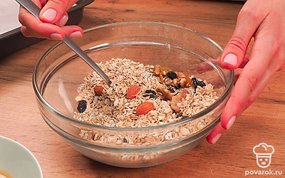 Насыпьте овсяные хлопья в миску и смешайте их с сухофруктами, орехами и кокосовой стружкой. Теперь к полученной смеси добавьте фруктовое пюре и снова все тщательно перемешайте.
