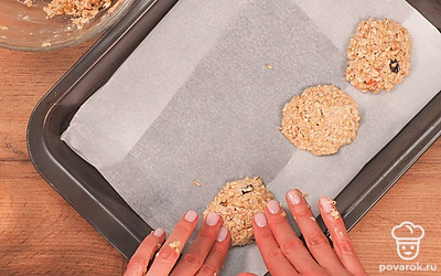 Смочите руки водой и начинайте формировать печенье, выкладывая его на противень, застеленный пергаментной бумагой.