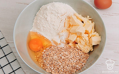 В глубокой миске смешайте овсянку, муку, мягкое масло, яйца, сахар и разрыхлитель.