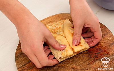 Выложите начинку на блинчики и сформируйте конвертики.