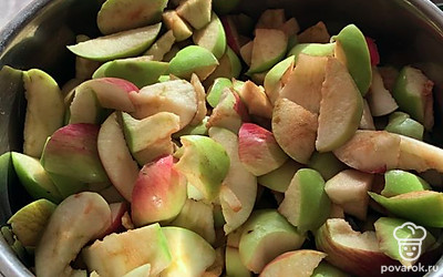 Нарежьте яблоки дольками и сразу уложите в удобную кастрюлю для варки.