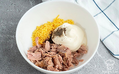 Очистите яйца, разрежьте их на половинки, удалите желток чайной ложкой. Желток мелко нарубите, перемешайте с майонезом и мясом тунца в отдельной посуде.Приправьте солью и перцем по вкусу.