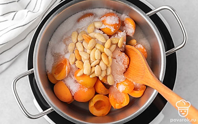 Переложите миндаль в кастрюлю с абрикосами, все перемешайте. Поставьте на средний огонь и дождитесь, когда сироп закипит.