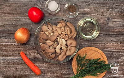 Почистите грибы. Удалите края ножек, срезав их ножом. Промойте в проточной воде и положите в большую кастрюлю. Подготовьте мясорубку. Очистите лук от шелухи. Вымойте и нарежьте кубиками. Вымойте морковь. Очистите от кожуры. Натрите на крупной терке. Вымойте помидоры. Разрежьте их на 3-4 части. Вымойте зелень. Измельчите ее при помощи ножа.