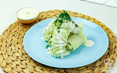 Готовые рулетики выложите на тарелку, полейте сметаной и посыпьте рубленым укропом.