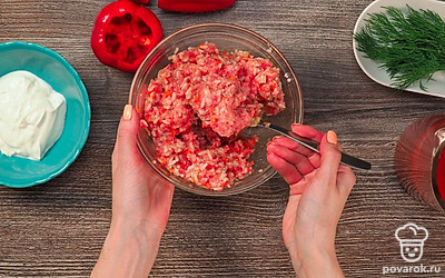 Приготовьте начинку и нафаршируйте перцы. Разогрейте глубокую сковороду с растительным маслом, обжарьте на ней лук и морковь в течение 5-7 минут. В миску поместите мясной фарш, добавьте рис и обжаренные овощи. Посолите, поперчите и тщательно перемешайте. Перец наполните получившимся фаршем.