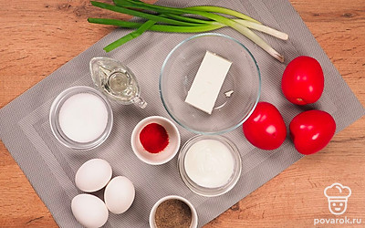 Удобно расположите все ингредиенты. Вымойте помидоры, зеленый лук. Порежьте мелко лук. Приготовьте жаропрочный противень. Включите духовку на 180 градусов.