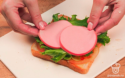Смажьте каждый ломтик хлеба сливочным маслом с одной стороны. Уложите начинку слоями на масло в следующей последовательности: кружочки томата, листья салата, кусочки колбасы и сыра. Закройте начинку вторым ломтиком хлеба (маслом – на начинку). Проделайте всё то же самое с двумя другими ломтиками хлеба и оставшимися ингредиентами для начинки.