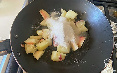 В сковороде соедините кусочки нектарина и сахар. 