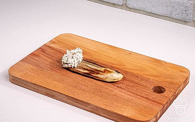 Дайте обжаренным баклажанам немного остыть, чтобы с ними было удобно работать. Возьмите один ломтик и выложите немного начинки на край.